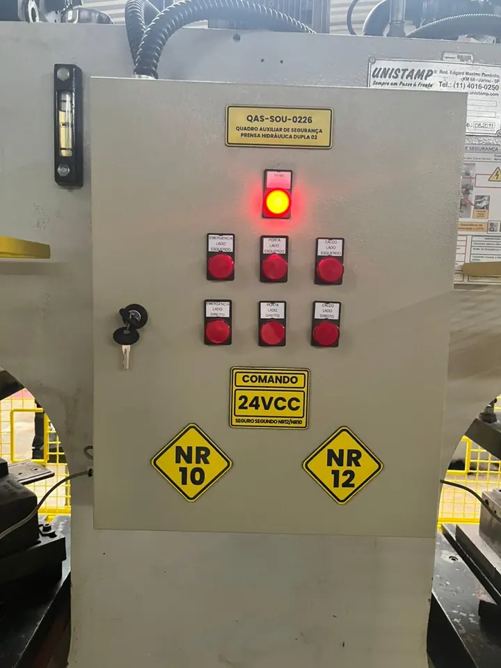 Painel de comando com botões luminosos e placas NR-10 e NR-12